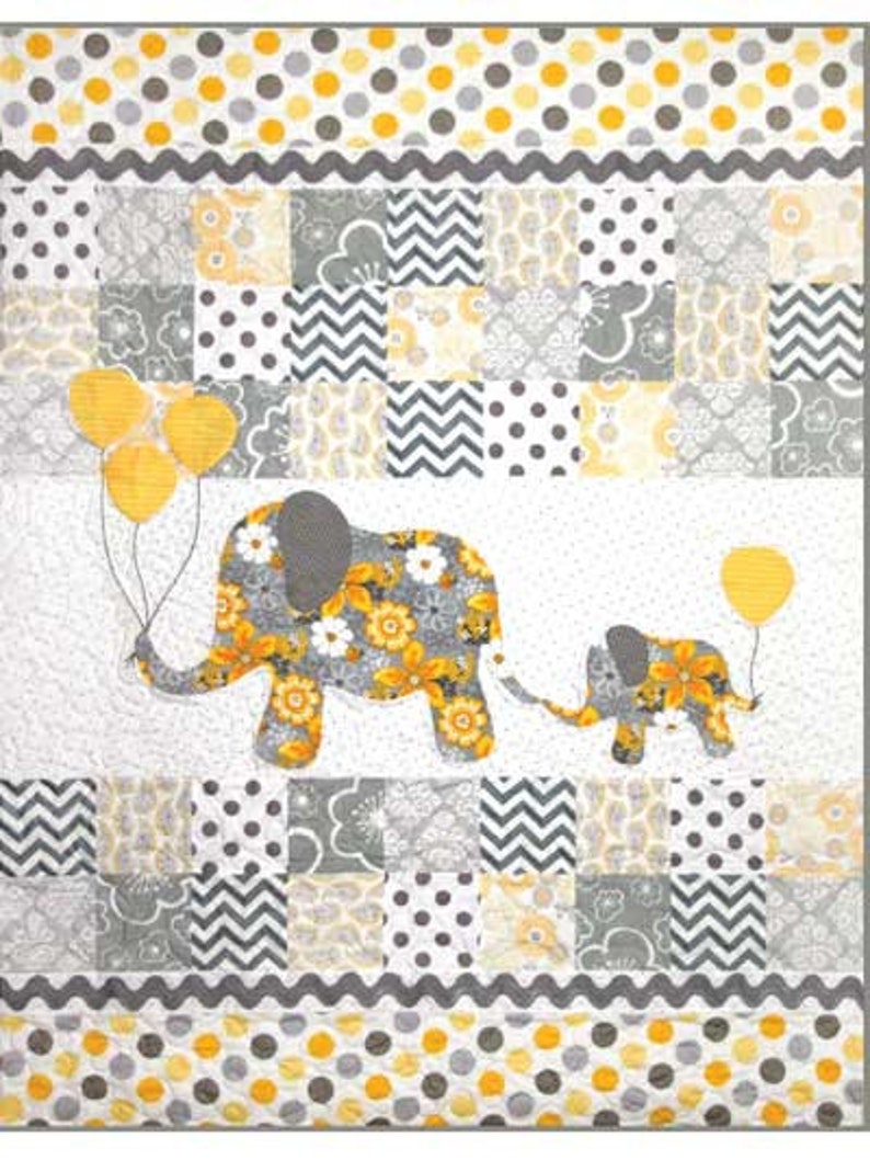 May include: A gray and yellow baby quilt with a patchwork design featuring elephants, balloons, and polka dots.