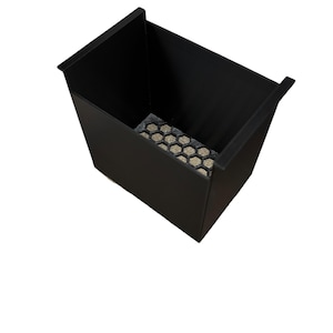 May include: A black rectangular container with a textured, honeycomb-patterned base. The container has a simple, modern design with a matte finish. The sides are straight and the top edges are slightly flared.