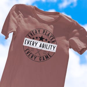 May include: A mauve t-shirt with a black and white graphic that reads "Every Player Every Ability Every Game". The graphic features a baseball, bats, and stars.