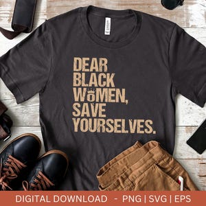 May include: A dark grey t-shirt with the text "DEAR BLACK WOMEN, SAVE YOURSELVES." printed in a light brown colour.