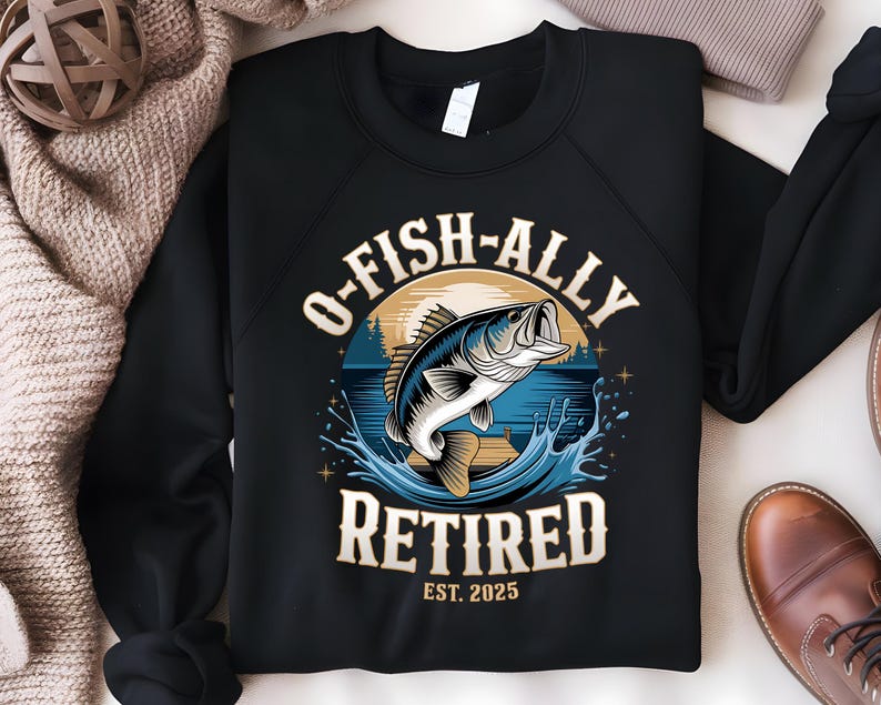 Puede incluir: Sudadera negra con un gr&aacute;fico de un pez saltando fuera del agua. El texto "O-Fish-Ally Retired Est. 2025" est&aacute; impreso en la sudadera.