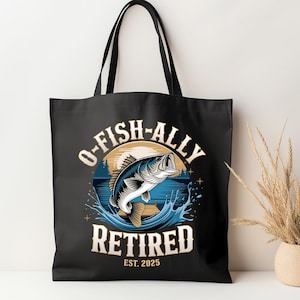 Puede incluir: Bolsa de tela negra con un gr&aacute;fico de un pez saltando fuera del agua. El texto "O-Fish-Ally Retired Est. 2025" est&aacute; impreso en la bolsa.
