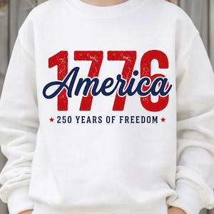 Pu&ograve; includere: Felpa bianca con la scritta "1776 America" in rosso e blu, con "250 YEARS OF FREEDOM" sotto. Il design presenta un aspetto vintage e usurato, perfetto per celebrare la storia e l'indipendenza americana.