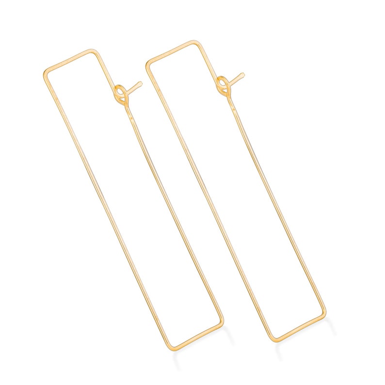 Puede incluir: Un par de pendientes de aro rectangulares de color dorado. Los pendientes est&aacute;n hechos de metal fino y tienen un dise&ntilde;o simple y minimalista.