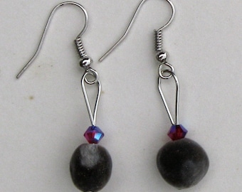 May include: A pair of silver earrings with a dark gray bead and a small iridescent purple and red crystal bead on each earring.