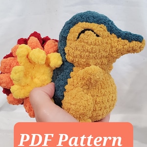 Könnte beinhalten: Ein handgefertigtes Plüschtier in Form einer Zeichentrickfigur. Das Spielzeug hat einen gelben Körper, einen blauen Kopf und einen mehrfarbigen Rücken. Der Text "PDF Pattern" wird auf einem orangefarbenen Rechteck angezeigt.