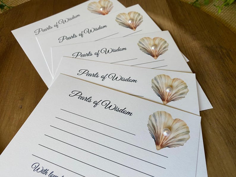 May include: A stack of white stationery cards with the words "Pearls of Wisdom" in elegant script. Each card features a seashell illustration with a pearl. The cards have lined spaces for writing.