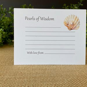 May include: White card with the text "Pearls of Wisdom" and lines for writing. A seashell with a pearl is in the upper right corner. The bottom of the card reads "With love from".