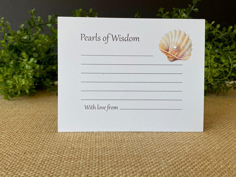 May include: White card with the text "Pearls of Wisdom" and lines for writing. A seashell with a pearl is in the upper right corner. The bottom of the card reads "With love from".