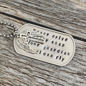 May include: Silver dog tag necklace with a cross and wings charm. The tag reads "Never drive faster than your guardian angel can fly."