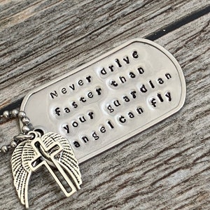 May include: Silver charm necklace with a silver angel wing and cross charm. The tag reads "Never drive faster than your guardian angel can fly."