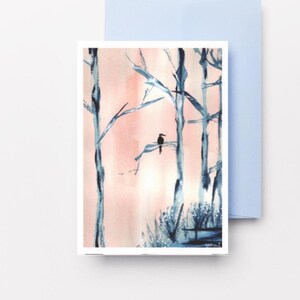 Peut inclure: Une carte de vœux rectangulaire présentant une illustration à l'aquarelle d'un petit oiseau sombre perché sur une branche entre de grands arbres bleus stylisés sur un fond rose pâle doux. Une enveloppe bleu clair assortie est placée derrière.