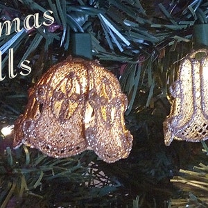 Puede incluir: Una cadena de luces navideñas con bombillas en forma de campana plateadas. Las luces están enhebradas en un cable verde y están encendidas. El texto "Christmas Bells" es visible en la imagen.