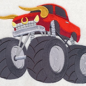 May include: A red monster truck with large black tires and gold horns. The truck has a silver grill and headlights.