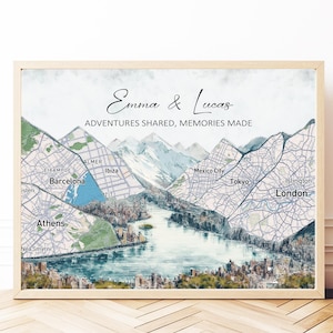 Op de afbeelding: Een ingelijste kaartafdruk met een aquarel landschap. Het kunstwerk integreert stadskaarten in bergketens. De afdruk draagt de namen "Emma & Lucas" en de zin "ADVENTURES SHARED, MEMORIES MADE". Steden als Londen en Barcelona zijn zichtbaar.