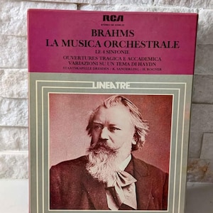 Könnte beinhalten: Ein Vintage-Vinyl-Schallplattenalbum mit einem Porträt von Johannes Brahms. Das Albumcover ist eine Mischung aus Burgunderrot und Grau, mit Text in mehreren Sprachen. Der Albumtitel lautet "La Musica Orchestrale" und enthält das RCA-Logo.