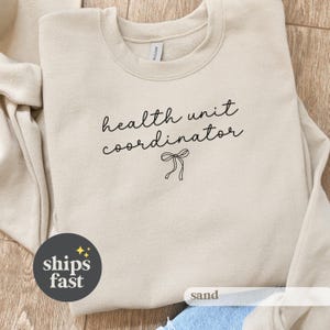 May include: A white ceramic mug with a black handle and the text "But First, Coffee" in a black, bold font. The mug is on a white surface. The mug is 4 inches tall.