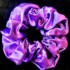 May include: A purple satin scrunchie for hair.