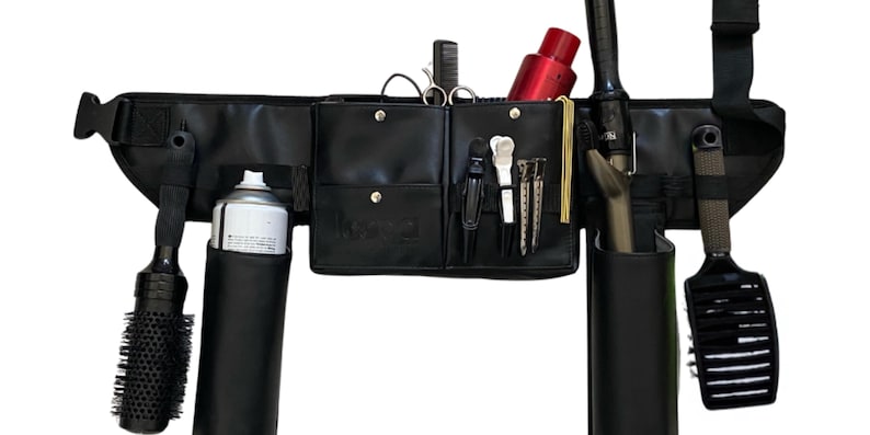 May include: Black leather stylist belt with multiple pockets and holders for tools, including a round brush, hairspray, shears, and a curling iron.