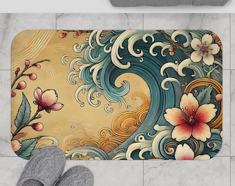 May include: A bath mat featuring a Japanese wave design in shades of blue, yellow, and white. The wave is surrounded by cherry blossoms in pink and white.