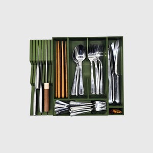 Puede incluir: Un organizador de cubiertos verde lleno de cubiertos de acero inoxidable, que incluye cuchillos, tenedores, cucharas y palillos. El organizador tiene m&uacute;ltiples compartimentos para mantener los utensilios ordenados. Los utensilios est&aacute;n ordenados.