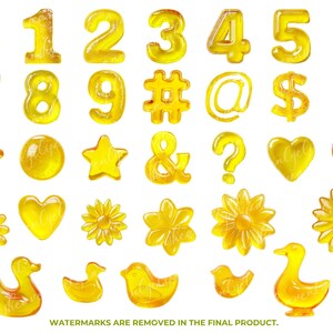 May include: A collection of yellow, translucent, gel-like shapes including numbers, symbols, stars, hearts, flowers, and ducks. The numbers 0-9 are present, along with symbols such as the hashtag, at sign, dollar sign, exclamation point, ampersand, and question mark.