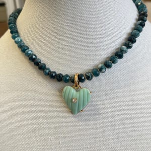 May include: A teal blue gemstone beaded necklace with a light green heart pendant featuring a small diamond accent.