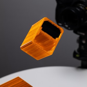 May include: A set of four orange plastic blocks with a textured surface. The blocks are stacked on top of each other.