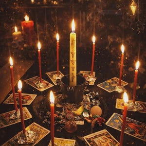 May include: A mystical scene with lit candles and tarot cards. A large central candle is surrounded by smaller red candles, all casting a warm glow. Various trinkets and charms are scattered around the cards, creating an atmosphere of divination and spirituality.