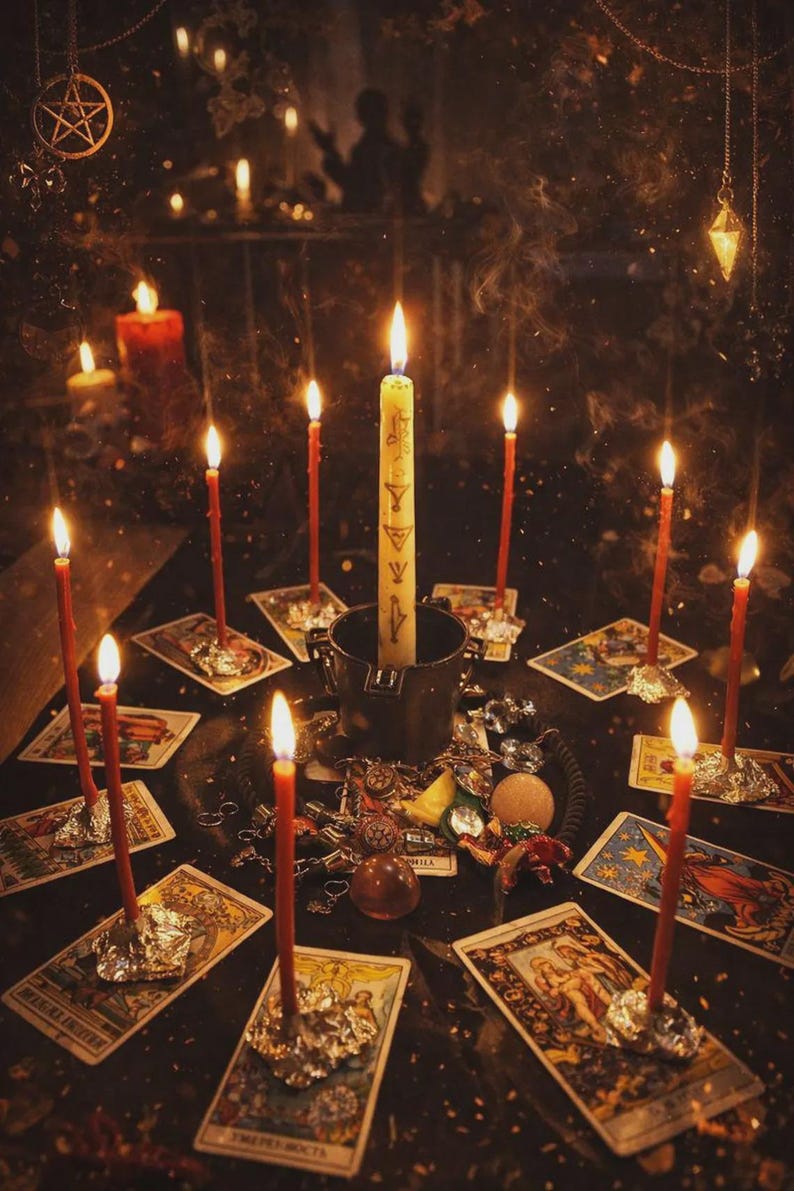 May include: A mystical scene with lit candles and tarot cards. A large central candle is surrounded by smaller red candles, all casting a warm glow. Various trinkets and charms are scattered around the cards, creating an atmosphere of divination and spirituality.