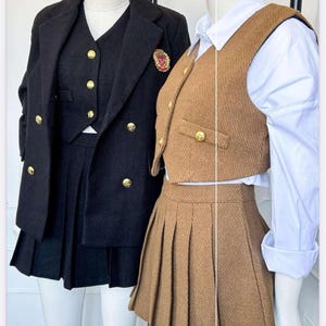 May include: Two school uniform-style outfits on mannequins. One is black with a blazer, vest, and pleated skirt, accented with gold buttons and a crest. The other is brown with a vest, pleated skirt, and white collared shirt.