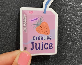 May include: A pink sticker in the shape of a juice carton with a blue straw. The sticker features a strawberry design and the words "Creative Juice" in purple. The text "Fast Results" is also included.