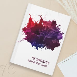 Könnte beinhalten: Ein weißes Journal mit einem farbenfrohen abstrakten Design auf dem Cover. Der Titel "The Living Water Scripture Study Journal" ist in schwarzer Schrift gedruckt.