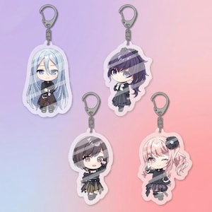 May include: Four anime-style character keyrings. Each keyring features a different character with unique hairstyles and outfits. The keyrings are attached to silver-coloured key rings. The background is a gradient of pink and purple.