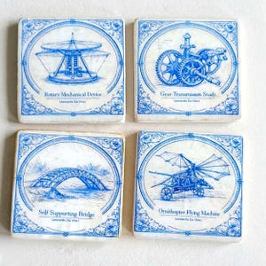 May include: Set of four square coasters with blue and white illustrations of Leonardo da Vinci's inventions. Each coaster features a different design: a rotary mechanical device, gear transmission study, self-supporting bridge, and ornithopter flying machine.
