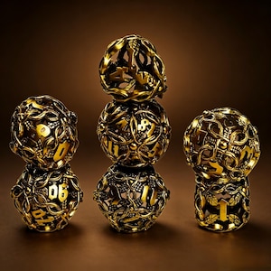 May include: A set of five spherical gold-colored dice featuring an intricate openwork design of intertwined vines and leaves. Each die has numbers cut out from the metal structure, with the dice arranged in three stacks of varying heights.