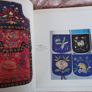 Op de afbeelding: Een close-up van een traditionele Chinese geborduurde tas met ingewikkelde ontwerpen. De tas is gemaakt van rood en blauw stof en heeft een verscheidenheid aan bloem- en geometrische patronen. De tas is versierd met een zwarte rand en een gouden kwast.
