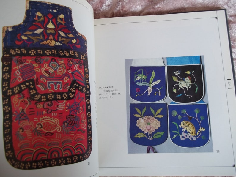 Op de afbeelding: Een close-up van een traditionele Chinese geborduurde tas met ingewikkelde ontwerpen. De tas is gemaakt van rood en blauw stof en heeft een verscheidenheid aan bloem- en geometrische patronen. De tas is versierd met een zwarte rand en een gouden kwast.