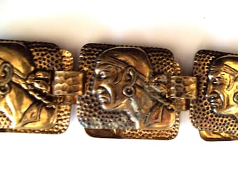 Cinturón vintage con relieve de pirata, efecto desgastado y acabado martillado en tono dorado. Cintura máxima: 71 cm (28"). Talla pequeña.