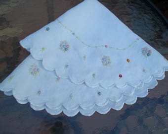 Gran mantel redondo de 60 cm (24") con bordado antiguo blanco sobre fondo pastel de nudos franceses y racimos de flores, de la década de 1920, sobre lino.