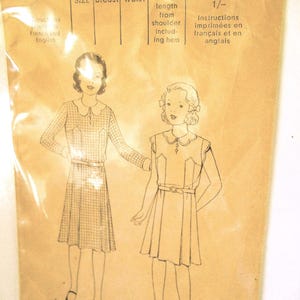Pode incluir: Padrão de costura vintage para um vestido de menina. O padrão apresenta dois modelos de vestidos com gola e cinto. O padrão inclui medidas em cm, tamanho 8, e instruções em francês e inglês. O preço é de 35 cêntimos.