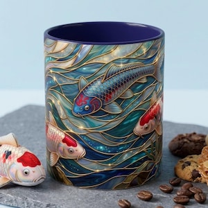 May include: A cylindrical ceramic mug featuring a vibrant, swirling pattern of blue and teal water with gold-lined waves. Three koi fish with red, white, and blue scales are depicted swimming through the water. The interior of the mug is dark blue.