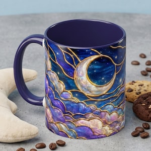Könnte beinhalten: Ein Keramikbecher mit dunkelviolettem Innenraum und Henkel, der ein lebendiges Außendesign mit einer Mondsichel und wirbelnden Wolken in tiefen Blau-, Violett- und Goldtönen zeigt, umrandet von einem goldfarbenen Buntglas-Muster.