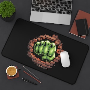 Könnte beinhalten: Schwarze Mauspad mit einer grünen Faust, die eine Ziegelmauer durchbricht. Die Faust leuchtet grün.