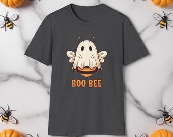 May include: Dark gray t-shirt featuring a cartoon ghost with bee wings and a striped abdomen. The text "BOO BEE" is printed in orange below the graphic. The shirt is surrounded by decorative pumpkins and bee accents.