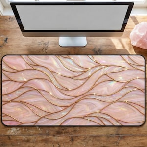May include: A rectangular mouse pad with a pink and gold wave design. The pad features a pattern of flowing, abstract waves in shades of pink, with gold-colored lines outlining the waves. The design has a shimmering, iridescent quality.