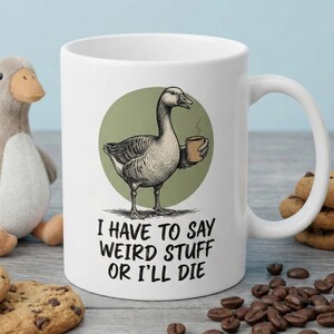 May include: White ceramic mug featuring a goose illustration holding a coffee cup, set on a green circle. The mug has the text "I HAVE TO SAY WEIRD STUFF OR I'LL DIE".