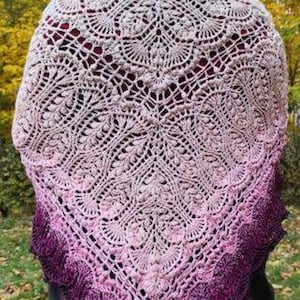 May include: A delicate crocheted shawl with a gradient of pink and purple hues. The shawl features a lacy pattern with intricate details.