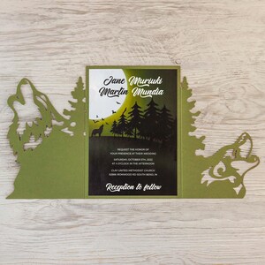 Könnte beinhalten: Eine grüne Hochzeitseinladung mit Waldthema. Die Einladung zeigt die Namen "Jane Muriuki" und "Martin Mundia" mit Veranstaltungsdetails. Das Design umfasst Silhouetten von Bäumen, einem Wolf und einem Vollmond.
