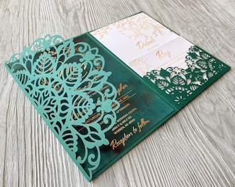 May include: A teal green wedding invitation with a laser cut design featuring a floral pattern. The invitation has gold foil accents and the text "SATURDAY" and "pher" are visible.